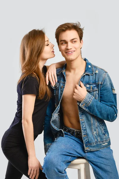 Denim kıyafet konsepti. Erkek omzuna yaslanan genç bir kadın..