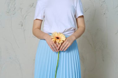 Cropped image of female hands holding flower