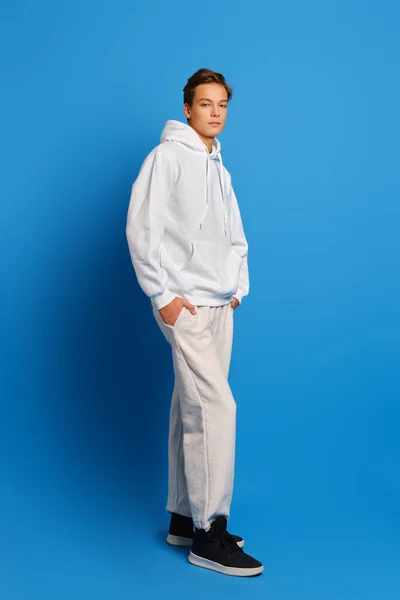 Young Man Wearing White Sweatshirt Sweatpants Standing Blue Studio Background Royalty Free Stock Photos