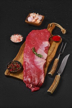 Tahta kesme tahtasındaki baharatlı çiğ pirzola rulosunun üst görüntüsü