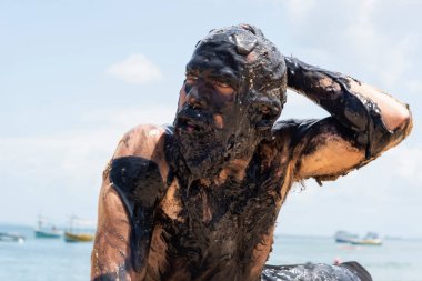 Bahia, Salvador 'daki Porto da Barra plajında petrole bulanmış bir adam, Brezilya sahillerinde bir geminin döktüğü petrolü protesto etmek için..