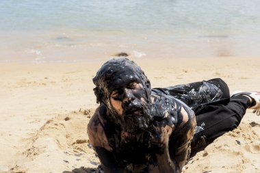 Bahia, Salvador 'daki Porto da Barra plajında petrole bulanmış bir adam, Brezilya sahillerinde bir geminin döktüğü petrolü protesto etmek için..