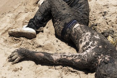 Bahia, Salvador 'daki Porto da Barra plajında petrole bulanmış bir adam, Brezilya sahillerinde bir geminin döktüğü petrolü protesto etmek için..