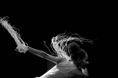 Çağdaş dansçı siyah arka plan ve saman aksesuarlarıyla tiyatroda dans ediyor. Salvador Bahia Brezilya.