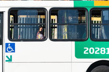 Salvador, Bahia, Brezilya - 30 Ekim 2020: Otobüsün içinde yüz maskesi takan kadın. Salvador Bahia Brezilya.