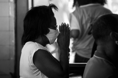 Salvador, Bahia, Brezilya - 01 Ocak 2021: Yüzü maskeli ve dua eden insanlar Salvador, Bahia, Brezilya 'daki Senhor do Bonfim kilisesinde.