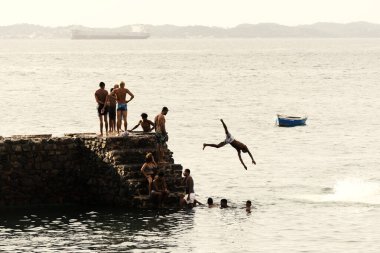 Salvador, Bahia, Brezilya - 08 Ocak 2019: Porto da Barra 'daki Santa Maria Kalesi' nden denize atlayan gençler.
