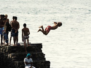 Salvador, Bahia, Brezilya - 08 Ocak 2019: Porto da Barra 'daki Santa Maria Kalesi' nden denize atlayan gençler.