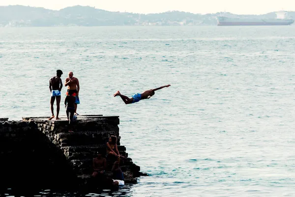 Salvador, Bahia, Brezilya - 08 Ocak 2019: Porto da Barra 'daki Santa Maria Kalesi' nden denize atlayan gençler.