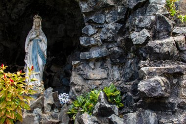 Salvador, Bahia, Brezilya - 30 Ekim 2014: Katolik Noel Baba, Salvador, Bahia, Brezilya çevresindeki bitkilerle dolu karanlık bir mağarada..
