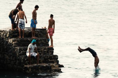 Salvador, Bahia, Brezilya - 08 Ocak 2019: Porto da Barra 'daki Santa Maria Kalesi' nden denize atlayan gençler.
