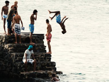 Salvador, Bahia, Brezilya - 08 Ocak 2019: Porto da Barra 'daki Santa Maria Kalesi' nden denize atlayan gençler.
