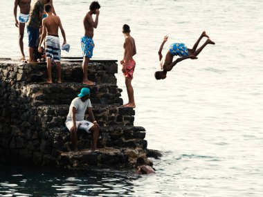 Salvador, Bahia, Brezilya - 08 Ocak 2019: Porto da Barra 'daki Santa Maria Kalesi' nden denize atlayan gençler.