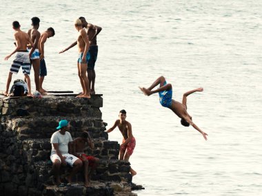 Salvador, Bahia, Brezilya - 08 Ocak 2019: Porto da Barra 'daki Santa Maria Kalesi' nden denize atlayan gençler.