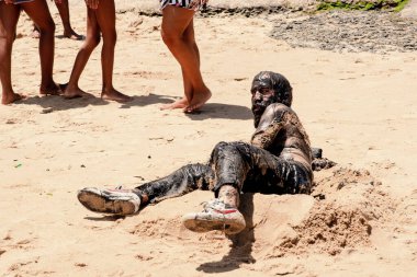 Adam Salvador 'daki Porto da Barra plajında Sarımsak ve Yağ' ın tiyatro performansını sergiliyor. Sahildeki insanlar onun performansını izliyor. Salvador Bahia Brezilya.