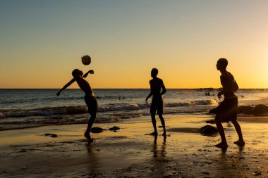 Salvador, Bahia, Brezilya - 08 Ocak 2020: Salvador, Bahia, Brezilya 'da gün batımında Ondina plajında kum futbolu oynayan gençler.