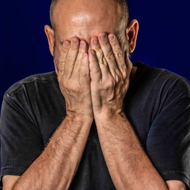 Mavi arka planda elleri yüzü olan biri. Salvador, Bahia, Brezilya.