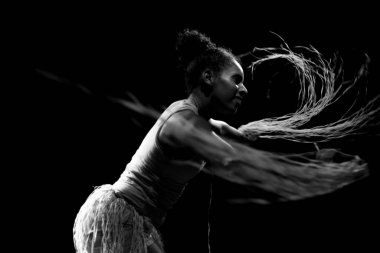 Çağdaş dansçı siyah arka plan ve saman aksesuarlarıyla tiyatroda dans ediyor. Salvador Bahia Brezilya.