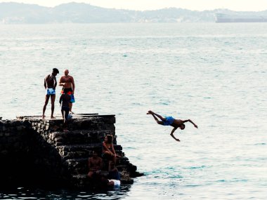 Salvador, Bahia, Brezilya - 08 Ocak 2019: Porto da Barra 'daki Santa Maria Kalesi' nden denize atlayan gençler.
