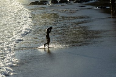Salvador, Bahia, Brezilya - 08 Ocak 2020: Adam banyo yaptıktan sonra yavaşça Ondina sahilinden geliyor. Salvador Bahia Brezilya.