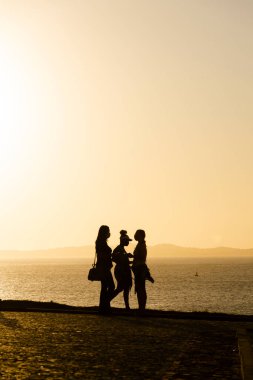 Salvador, Bahia, Brezilya - 29 Temmuz 2021: Gün batımına karşı bir grup insanın silueti. Salvador, Bahia, Brezilya.