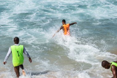 Salvador, Bahia, Brezilya - 15 Ağustos 2021: Brezilya 'nın Bahia kentindeki Farol da Barra sahilinde kum futbolu oynayan insanlar.