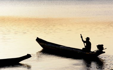 Cachoeira, Bahia, Brezilya - 29 Kasım 2014: Brezilya 'nın Bahia eyaletinde yer alan Paraguacu Nehri' ndeki teknesinde bir balıkçının günbatımında siluet.