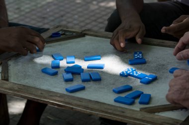  Eller tahtada oynamak için domino taşlarını topluyor. Cachoeira, Bahia, Brezilya.