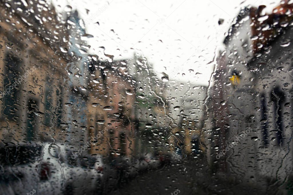 Wet glass, car inside view of street with buildings and houses. Salvador, Bahia, Brazil.