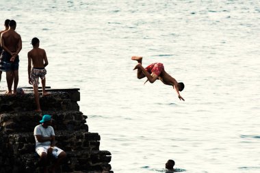 Salvador, Bahia, Brezilya - 08 Ocak 2019: Porto da Barra 'daki Santa Maria Kalesi' nden denize atlayan gençler.