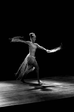 Çağdaş dansçı siyah arka plan ve saman aksesuarlarıyla tiyatroda dans ediyor. Salvador Bahia Brezilya.