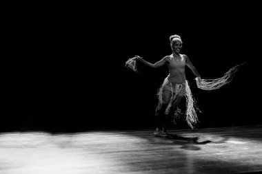 Çağdaş dansçı siyah arka plan ve saman aksesuarlarıyla tiyatroda dans ediyor. Salvador Bahia Brezilya.