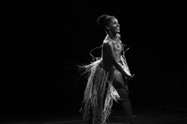 Çağdaş dansçı siyah arka plan ve saman aksesuarlarıyla tiyatroda dans ediyor. Salvador Bahia Brezilya.