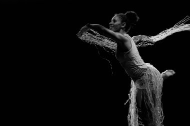 Çağdaş dansçı siyah arka plan ve saman aksesuarlarıyla tiyatroda dans ediyor. Salvador Bahia Brezilya.