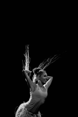 Çağdaş dansçı siyah arka plan ve saman aksesuarlarıyla tiyatroda dans ediyor. Salvador Bahia Brezilya.