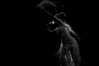 Çağdaş dansçı siyah arka plan ve saman aksesuarlarıyla tiyatroda dans ediyor. Salvador Bahia Brezilya.