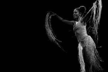 Çağdaş dansçı siyah arka plan ve saman aksesuarlarıyla tiyatroda dans ediyor. Salvador Bahia Brezilya.