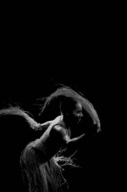 Çağdaş dansçı siyah arka plan ve saman aksesuarlarıyla tiyatroda dans ediyor. Salvador Bahia Brezilya.