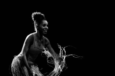 Çağdaş dansçı siyah arka plan ve saman aksesuarlarıyla tiyatroda dans ediyor. Salvador Bahia Brezilya.