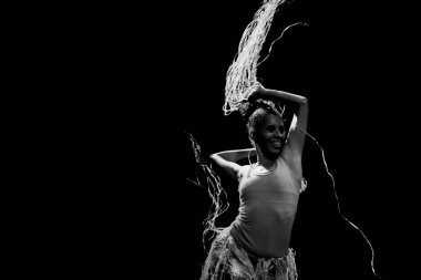 Çağdaş dansçı siyah arka plan ve saman aksesuarlarıyla tiyatroda dans ediyor. Salvador Bahia Brezilya.