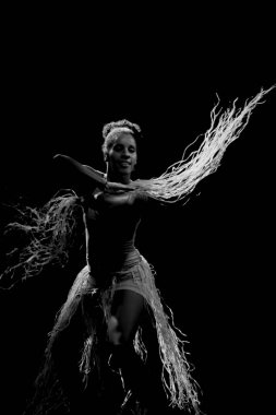 Çağdaş dansçı siyah arka plan ve saman aksesuarlarıyla tiyatroda dans ediyor. Salvador Bahia Brezilya.