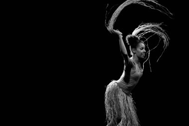 Çağdaş dansçı siyah arka plan ve saman aksesuarlarıyla tiyatroda dans ediyor. Salvador Bahia Brezilya.