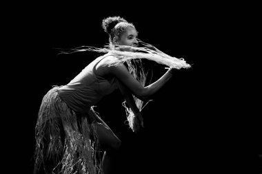 Çağdaş dansçı siyah arka plan ve saman aksesuarlarıyla tiyatroda dans ediyor. Salvador Bahia Brezilya.