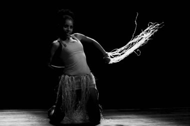 Çağdaş dansçı siyah arka plan ve saman aksesuarlarıyla tiyatroda dans ediyor. Salvador Bahia Brezilya.