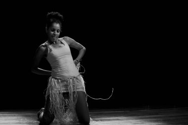 Çağdaş dansçı siyah arka plan ve saman aksesuarlarıyla tiyatroda dans ediyor. Salvador Bahia Brezilya.