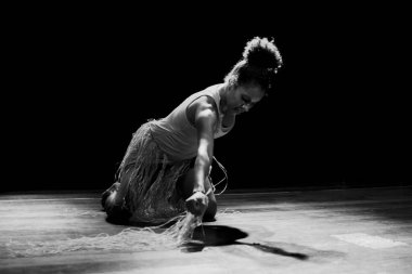 Çağdaş dansçı siyah arka plan ve saman aksesuarlarıyla tiyatroda dans ediyor. Salvador Bahia Brezilya.