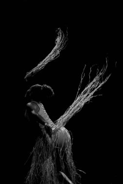 Çağdaş dansçı siyah arka plan ve saman aksesuarlarıyla tiyatroda dans ediyor. Salvador Bahia Brezilya.