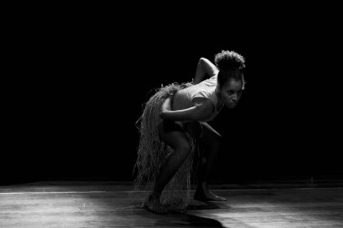 Çağdaş dansçı siyah arka plan ve saman aksesuarlarıyla tiyatroda dans ediyor. Salvador Bahia Brezilya.