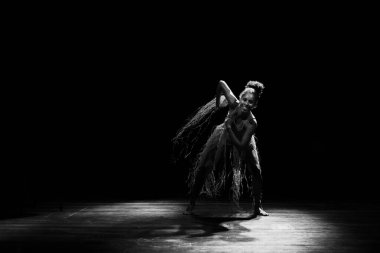 Çağdaş dansçı siyah arka plan ve saman aksesuarlarıyla tiyatroda dans ediyor. Salvador Bahia Brezilya.