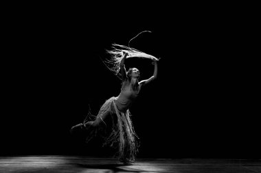 Çağdaş dansçı siyah arka plan ve saman aksesuarlarıyla tiyatroda dans ediyor. Salvador Bahia Brezilya.